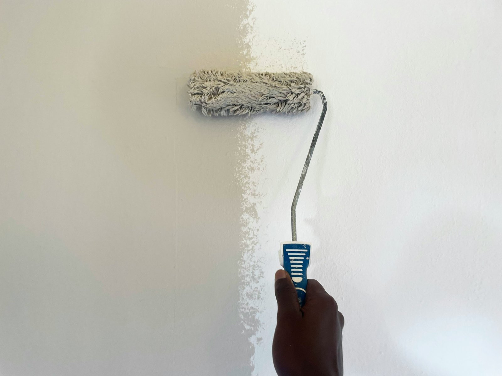 a man painting a wall with yellow paint